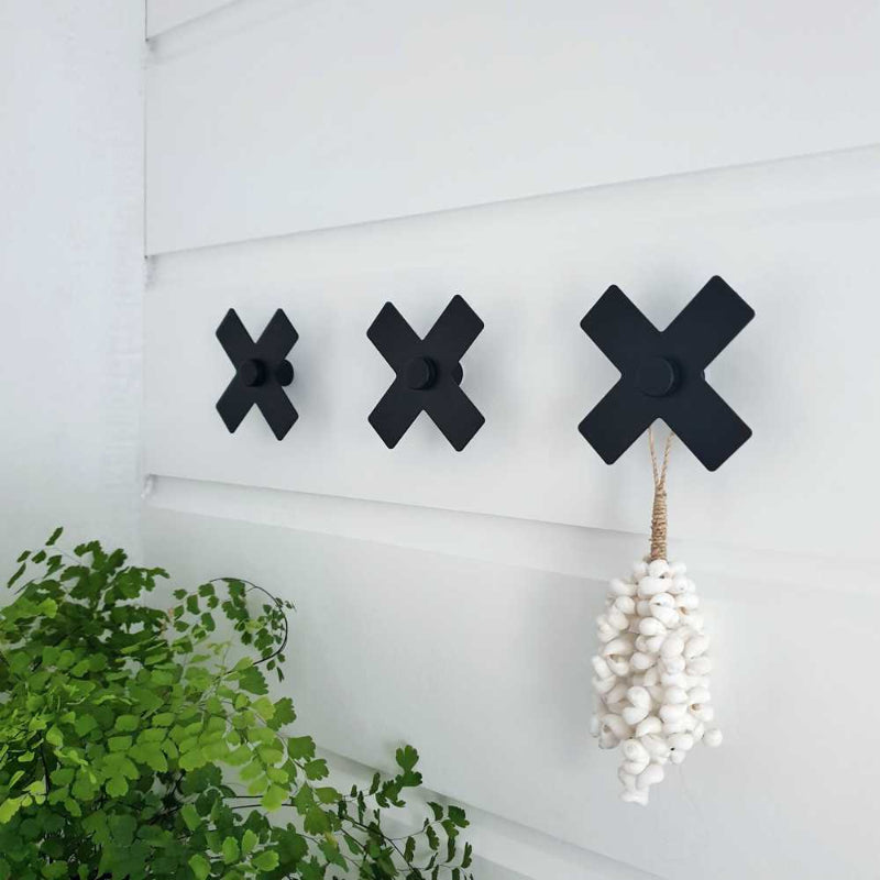 Black steel wall hooks on outdoor wall - NZ-made coat and towel hooks for indoors or out.