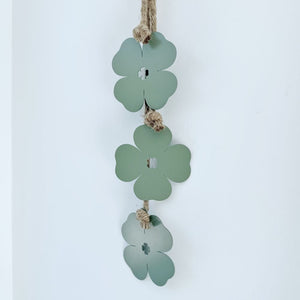 Decorative hanging with green clover-shaped leaves on a white background