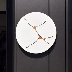 Large round white and gold wall art in aluminium on outdoor wall in modern home. 