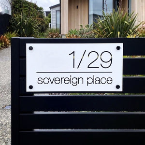 monochrome white steel address sign on modern black aluminium fence in new zealand