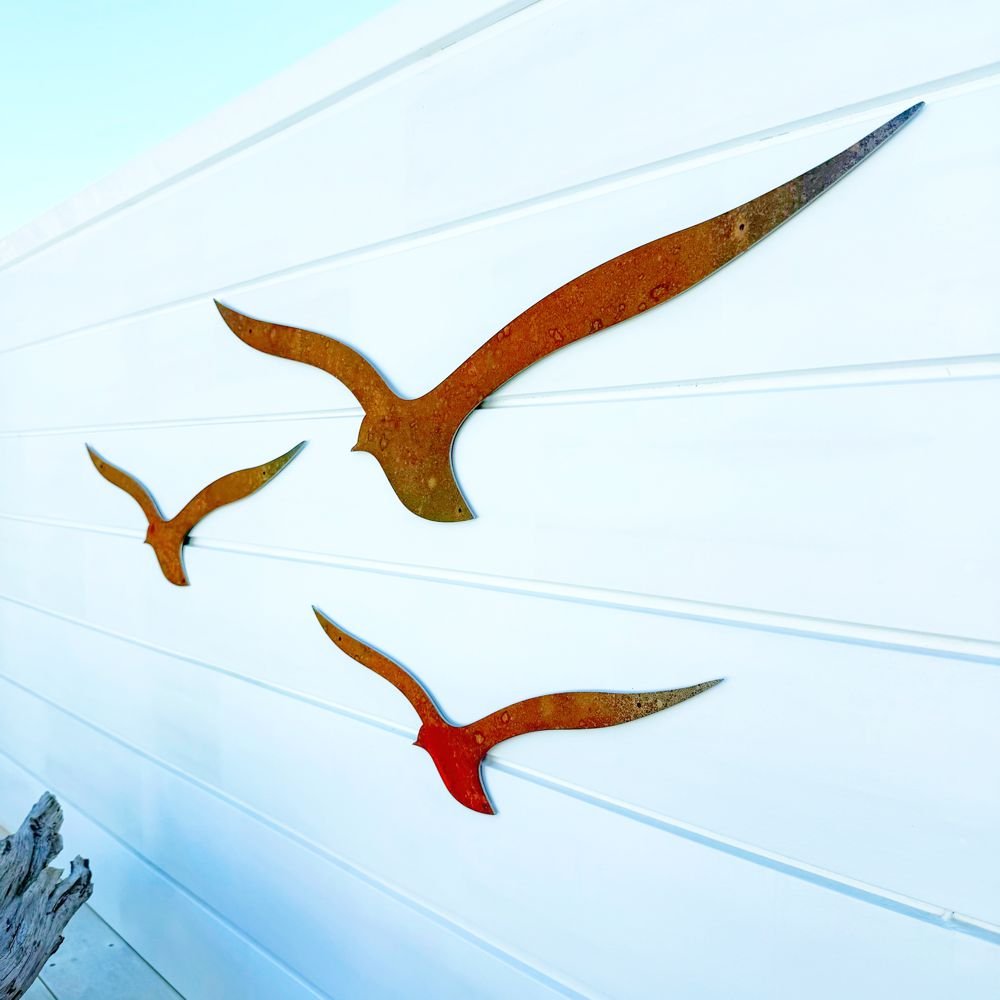 Outdoor Wall Art - birds in corten steel and a piece of driftwood by a pool.by a pool in New Zealand.