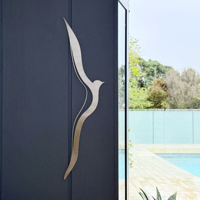 Decorative bronze luxe wall art for indoors and outdoors hung next to a pool in a New Zealand back yard. 