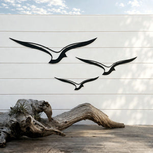 Set of three black aluminium birds mounted on an outdoor wall, NZ-made garden wall art by LisaSarah.