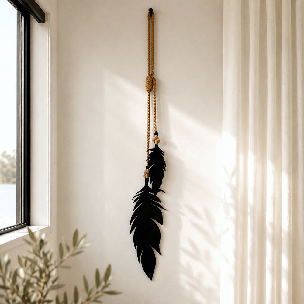 Black feather wall art hanging in a modern New Zealand living room with natural rope detail and minimalist neutral interior styling