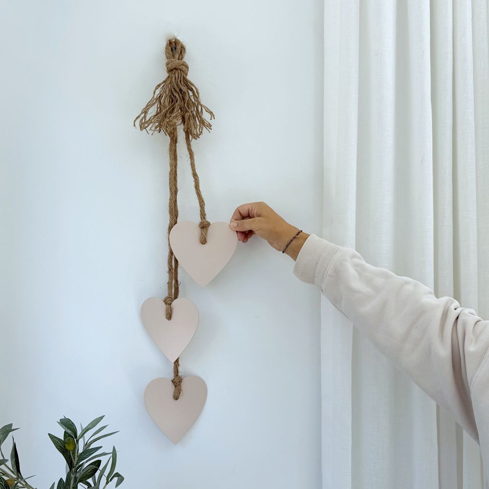 Blush pink stainless steel hearts wall hanging styled in a New Zealand living room, elegant gift and home décor by LisaSarah