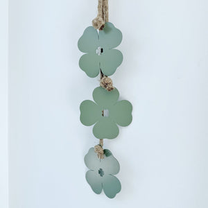Decorative hanging with green clover-shaped leaves on a white background