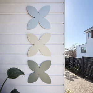 Coastal frangipani wall art set of 3 at entryway of modern home in Mairangi Bay Auckland, outdoor wall decor NZ made steel