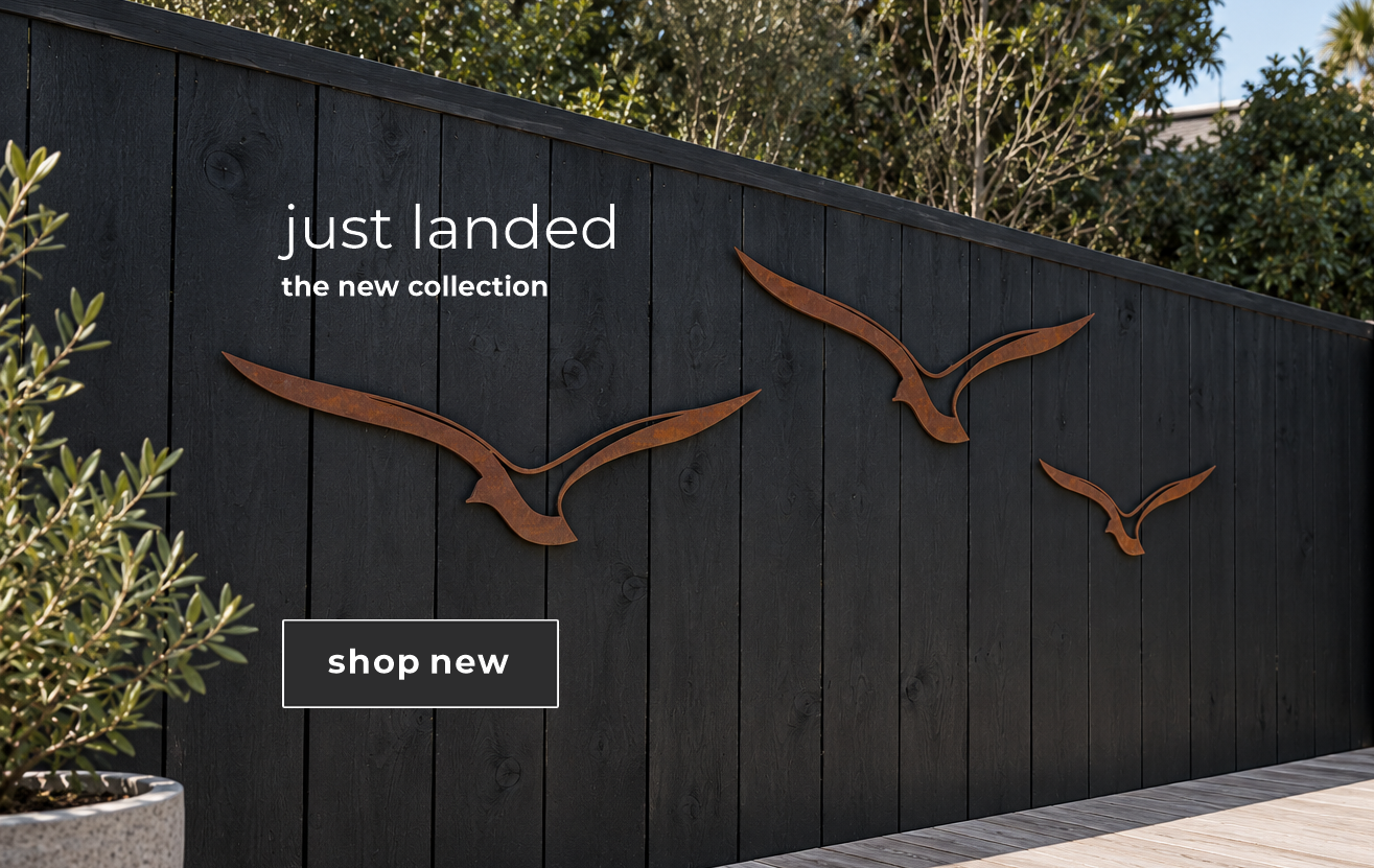 Corten steel birds wall art on fence in home in New Zealand. 