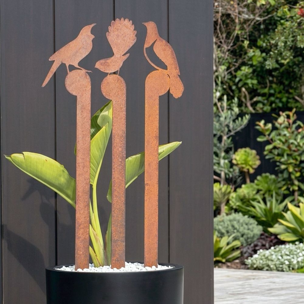 Garden corten steel metal birds in planter in New Zealand backyard space. 
