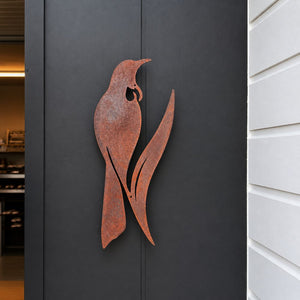 Corten steel tui silhouette wall art, 60cm tall, mounted on an outdoor wall in New Zealand