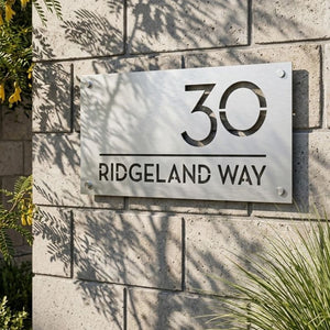Custom address sign with modern house numbers on exterior wall of contemporary New Zealand home