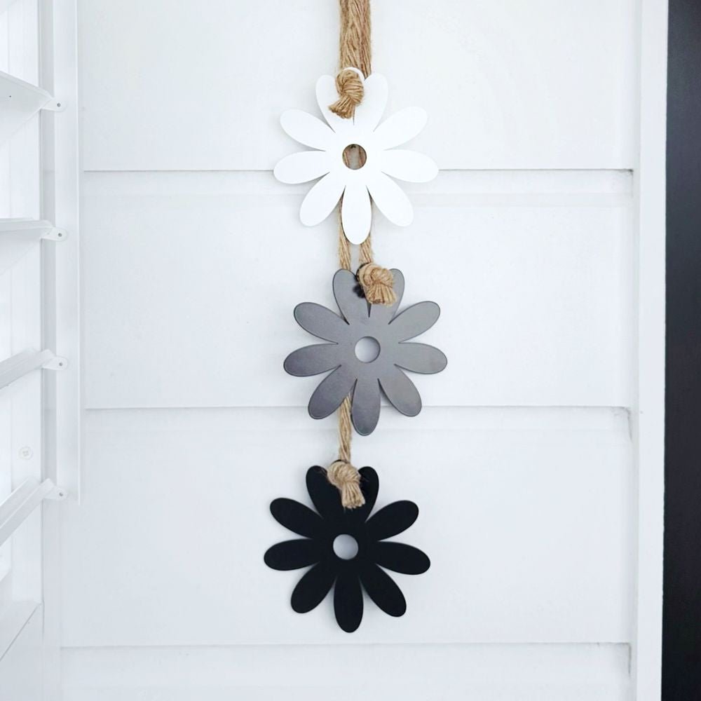 Steel Daisy & Rope Wall Hanging displayed on a New Zealand patio, handcrafted from durable steel with UV-resistant coating, adding elegant floral charm to outdoor décor.
