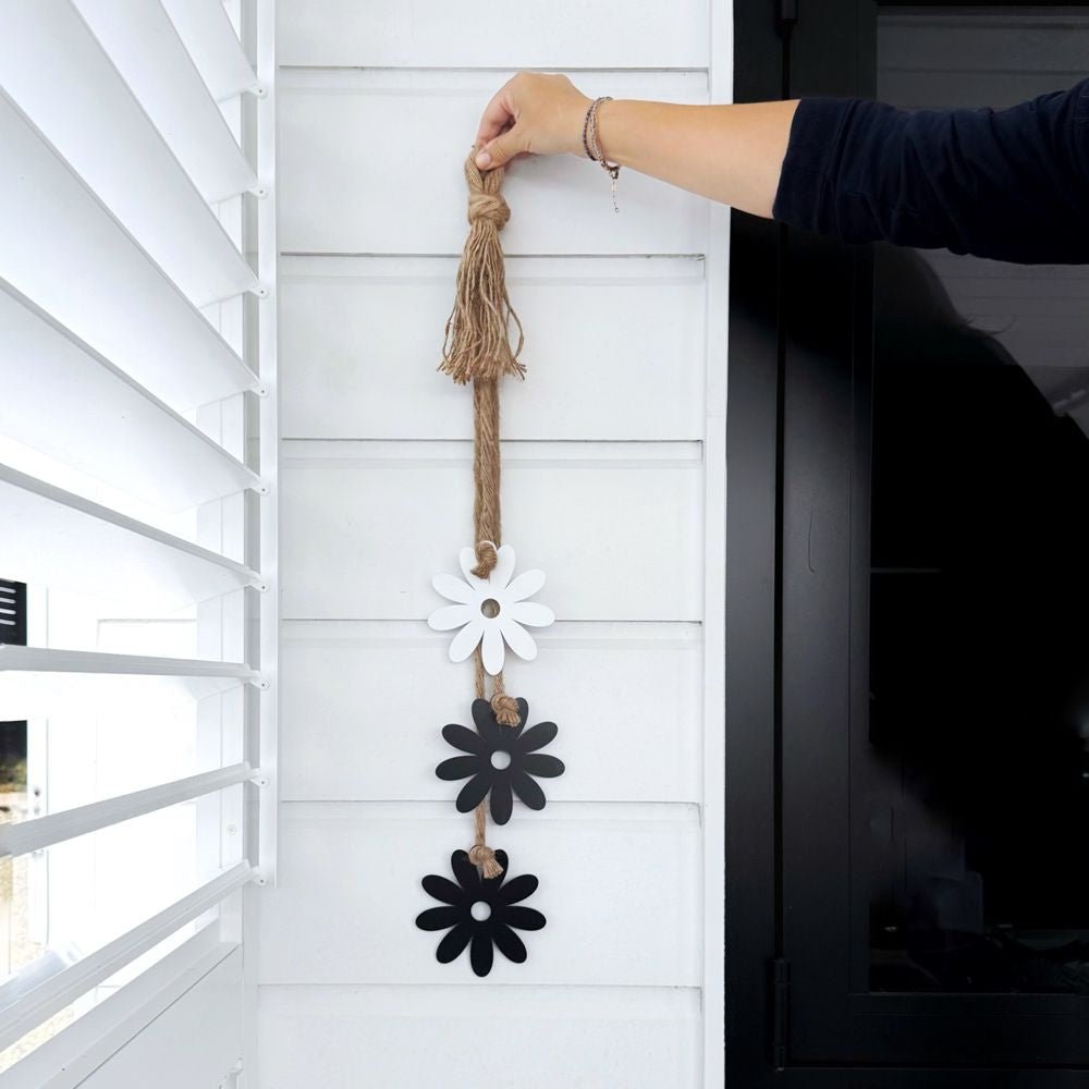 Steel Daisy & Rope Wall Hanging displayed on a New Zealand patio, handcrafted from durable steel with UV-resistant coating, adding elegant floral charm to outdoor décor.