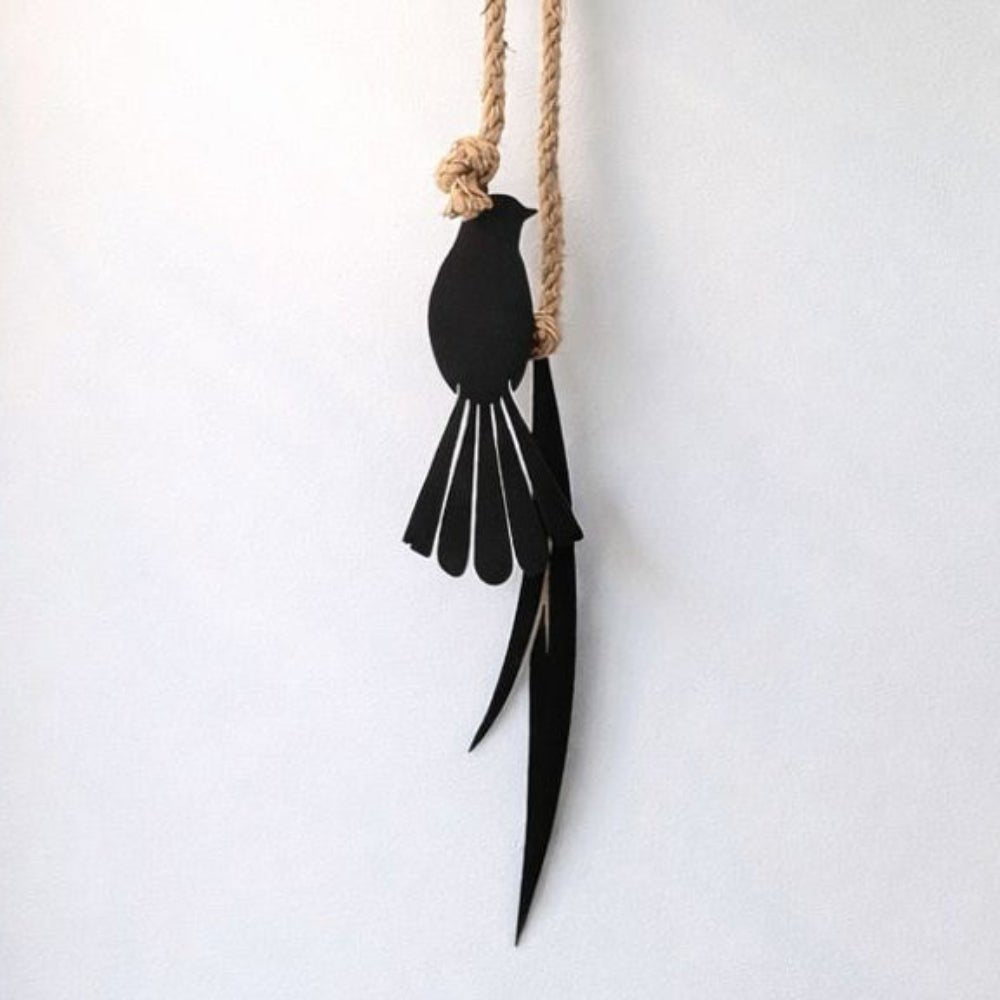 Fantail and flax metal wall hanging installed indoors on living room wall in New Zealand