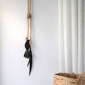 Fantail and flax metal wall hanging installed indoors on living room wall in New Zealand