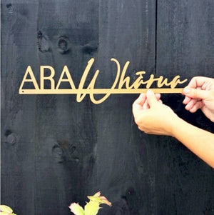 Personalised sign for family home in New Zealand on black fence. 