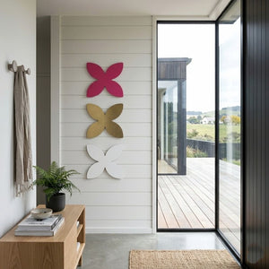 White, hot pink and gold frangipani metal wall art displayed in a modern architectural home entryway in New Zealand