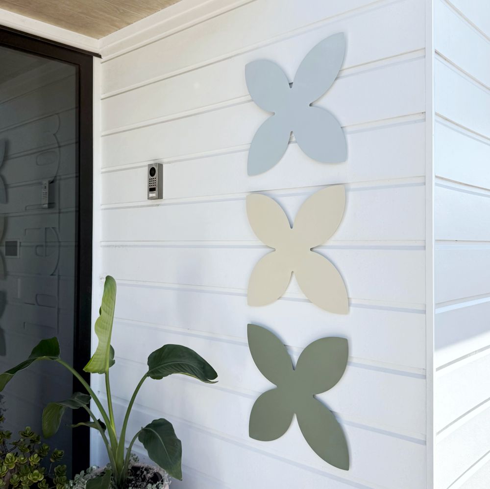 Coastal frangipani wall art set of 3 at entryway of modern home in Mairangi Bay Auckland, outdoor wall decor NZ made steel