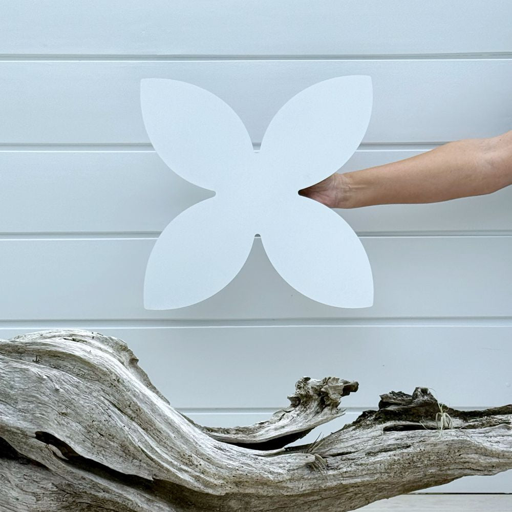 Marine-grade white steel frangipani artwork displayed in a coastal NZ garden setting