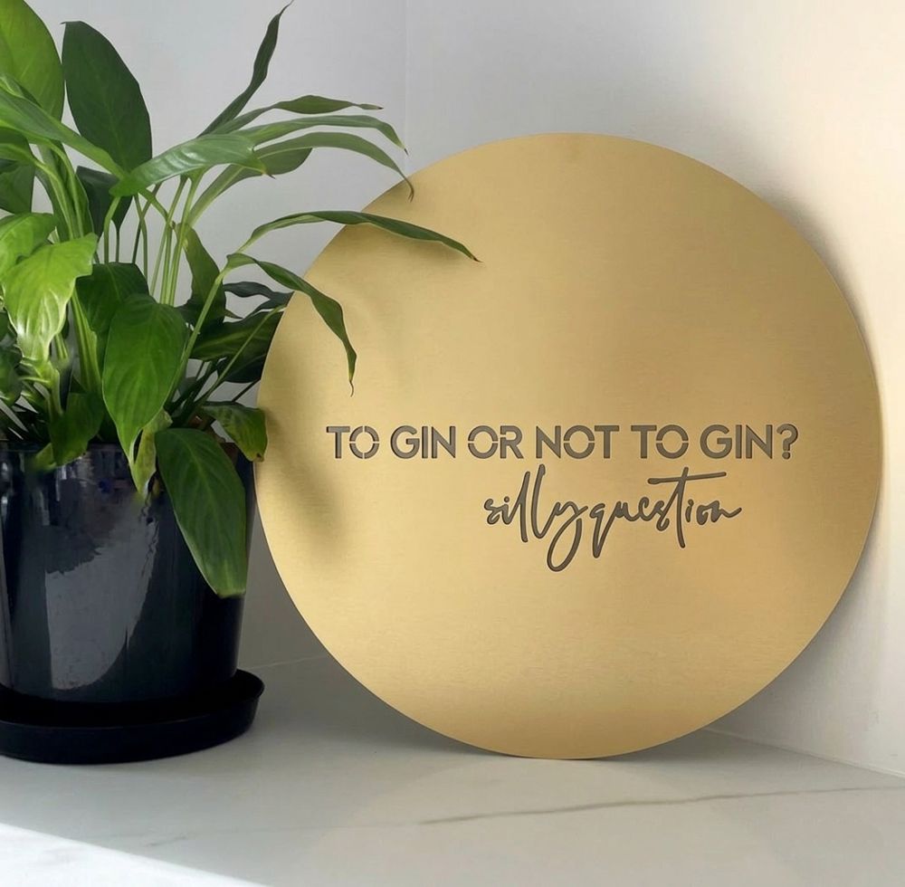 Matte gold steel “to gin or not to gin” wall art in a modern white kitchen in Auckland, New Zealand