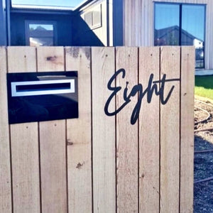 modern timber letter box in New Zealand with handwritten house number in words in black steel.