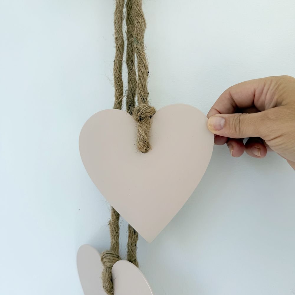 Blush pink stainless steel hearts wall hanging styled in a New Zealand living room, elegant gift and home décor by LisaSarah