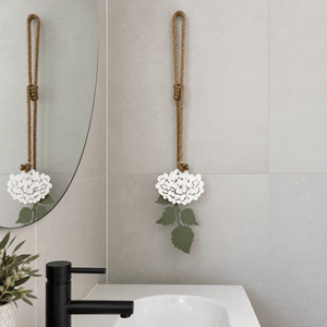 White powder-coated steel hydrangea wall art styled above a bathroom vanity