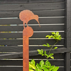 Large corten steel kiwi garden sculpture stake in a native New Zealand garden. 