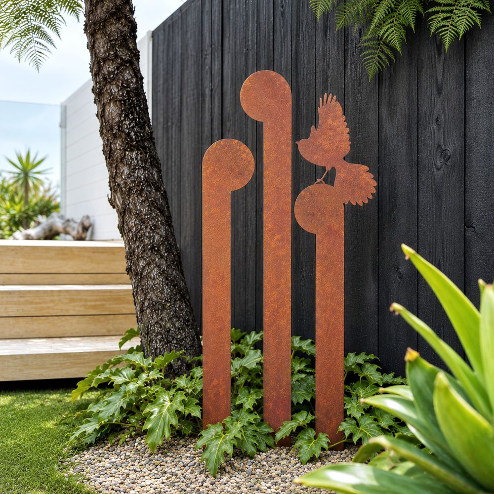 Set of 3 corten steel koru and fantail garden stakes in a New Zealand garden