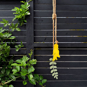 Yellow and sage kowhai wall hanging in powdercoated steel on a fence in New Zealand
