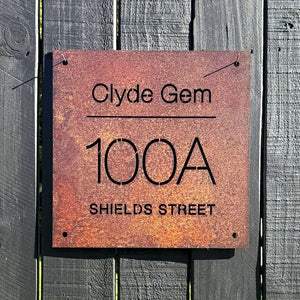 Custom property name sign for historic homestead in Clyde, New Zealand on black fence. 