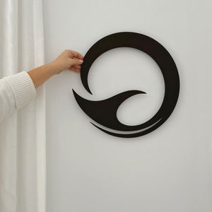 Matt black whale tail circle wall art next to a linen curtain in a New Zealand living room
