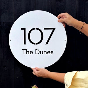 modern round white steel address sign on coastal New Zealand home exterior