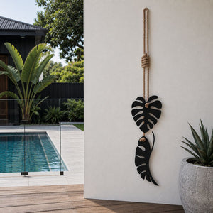 Monstera black metal wall art hanging in modern pool space in New Zealand home