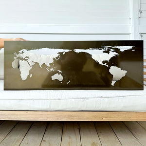 World map wall art on a wooden surface with a white wall background