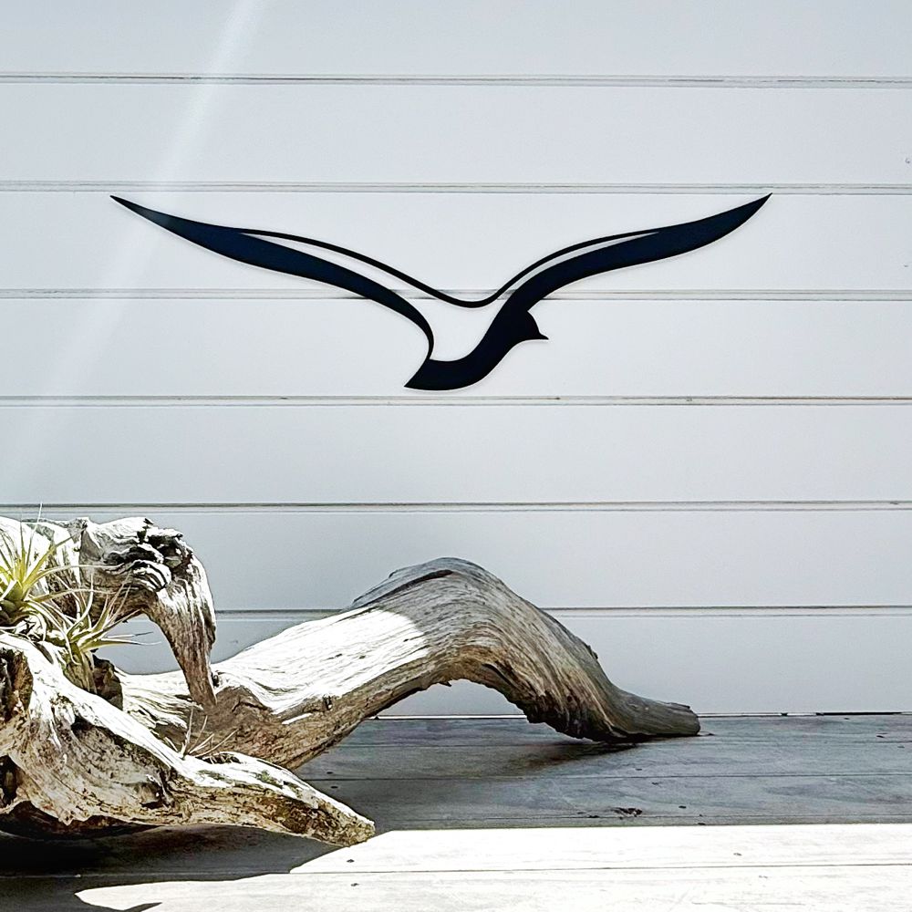 Contemporary aluminium bird outdoor wall art installed beside a pool on a modern home exterior, NZ made metal wall decor for gardens and patios.
