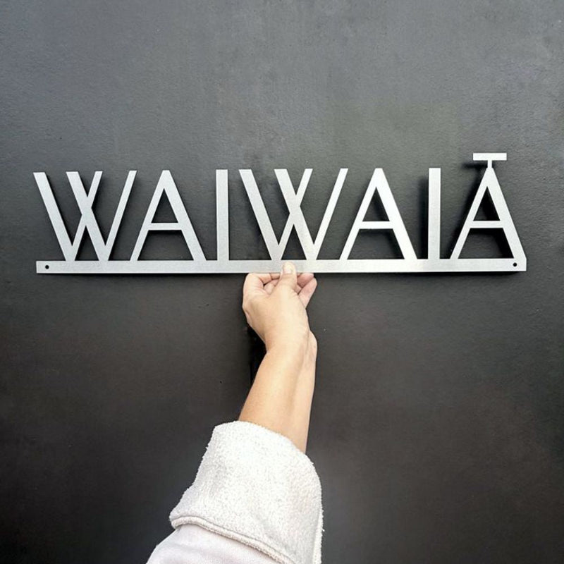 Csutom House Name sign - Marine grade stainless steel laser cut against a dark gray textured wall in Auckland.