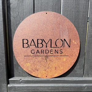 Corten steel round custom business sign on outdoor fence in Auckland, New Zealand