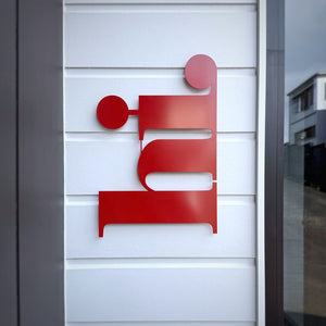 Red steel wall art 'hi' entryway decor of New Zealand home. 