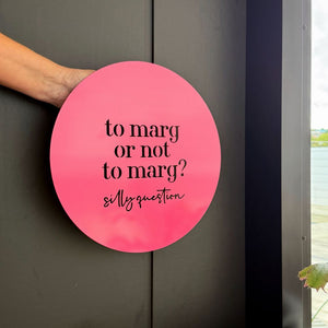 Side view of bright pink ‘to marg or not to marg’ wall art styled in a modern backyard — perfect gift for margarita lovers