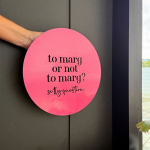 Side view of bright pink ‘to marg or not to marg’ wall art styled in a modern backyard — perfect gift for margarita lovers