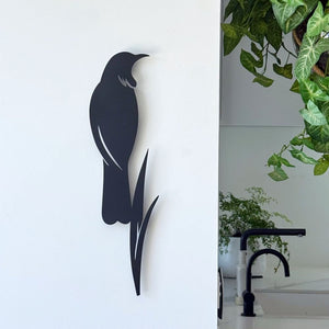 Tui and flax wall art in matt black aluminium displayed in a modern New Zealand living room