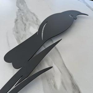 Close up of modern tui and flax silhouette wall art in matt black aluminium.