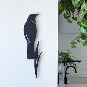 Tui and flax wall art in matt black aluminium displayed in a modern New Zealand living room