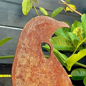 Close up of corten steel tui rusty garden stake in New Zealand garden