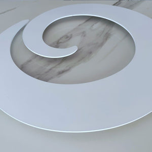 Minimal white circular metal wall art inspired by a koru-like unfurling fern form in aluminium