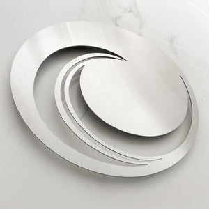 Close up of NZ designer Lisa Turley's brushed stainless steel wave wall art for outdoors. 