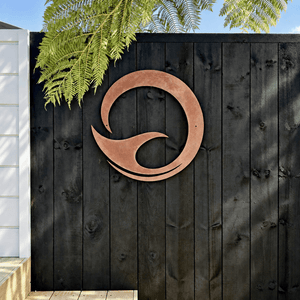 Round corten steel whale tail art on fence in Auckland, New Zealand. 